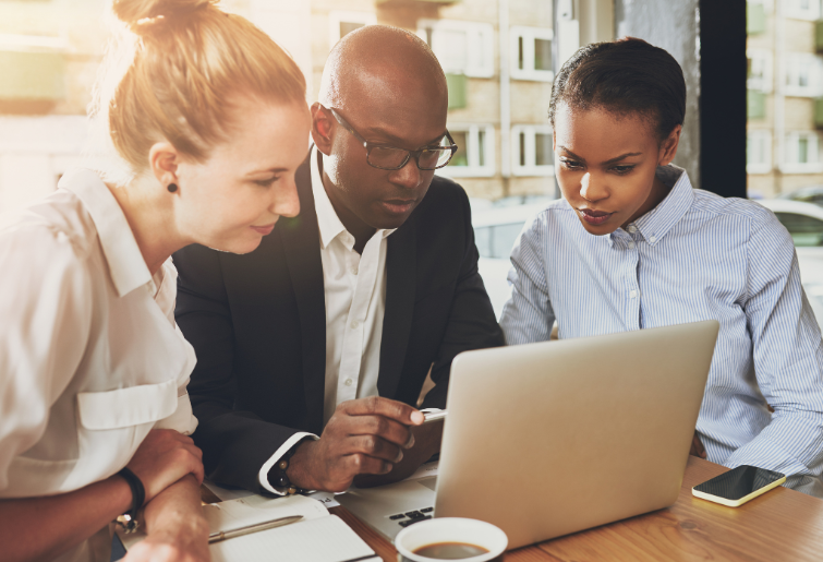 Business people working together looking at the same laptop screen